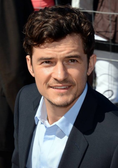 Orlando Bloom in Hemd und Sakko. Er hat kurze dunkle, gewellte Haare.